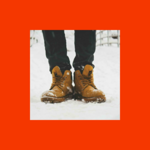 Person wearing boots on snow-covered ground.